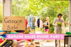 Garage sale on cardboard sign, rack of clothes, women shopping with trees in the background