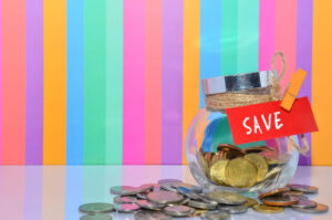 rainbow striped background, glass jar with money labeled savings