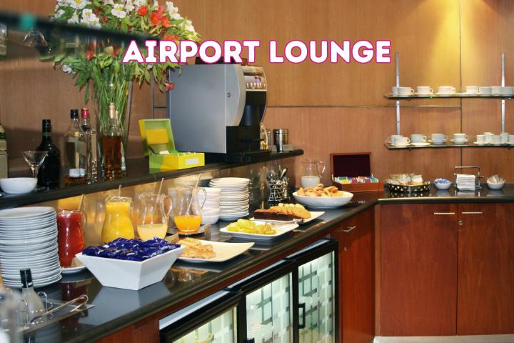 corner of vip lounge of an airport. colorful jars of juices and plates of fruit and snacks.