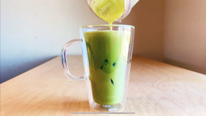 pouring iced matcha out of a magic bullet into a glass mug