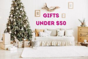 Text: Gifts Under $50, Image: White living room with Christmas tree on left and gifts and cozy couch in the middle