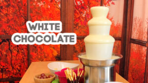 text: white chocolate, image: white chocolate fountain with red background